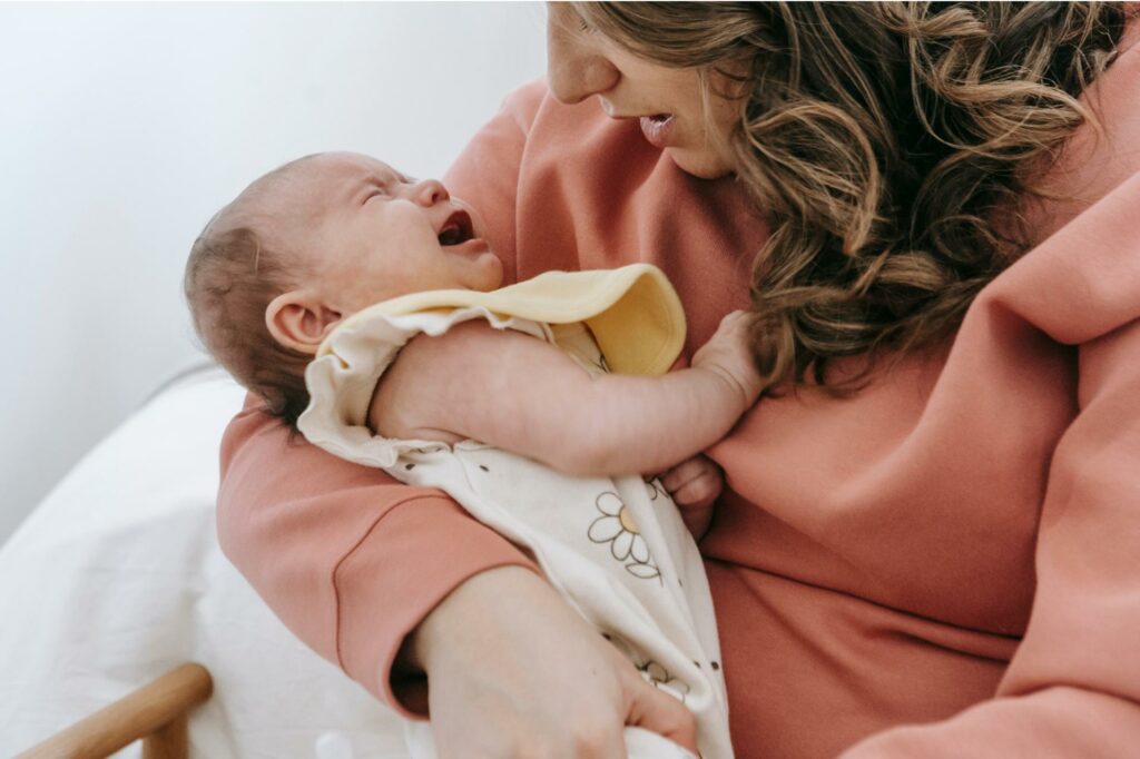 Bébé pleure dans les bras de sa maman